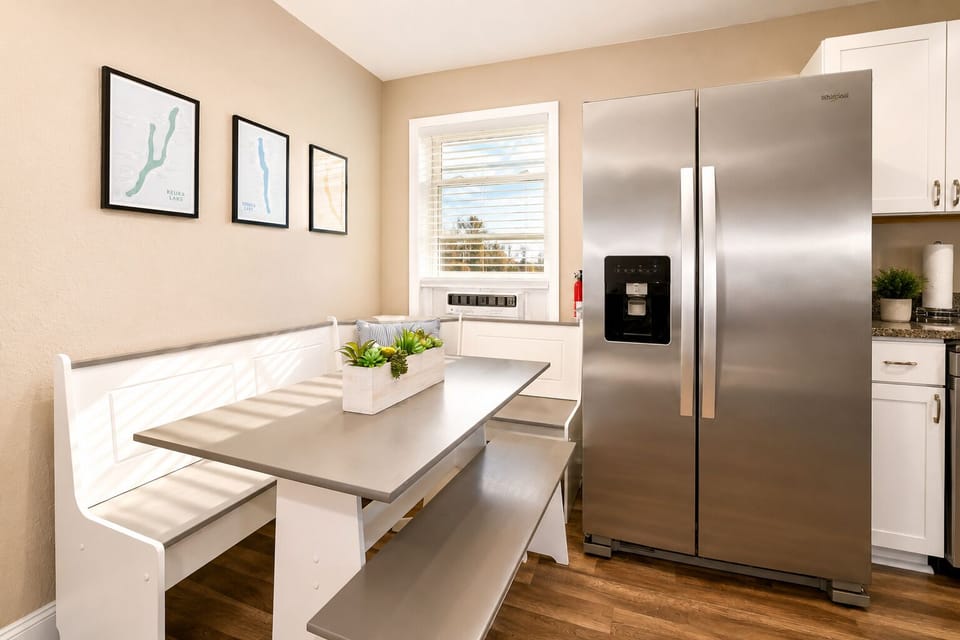 Bright kitchen nook with built-in bench seating and modern stainless fridge