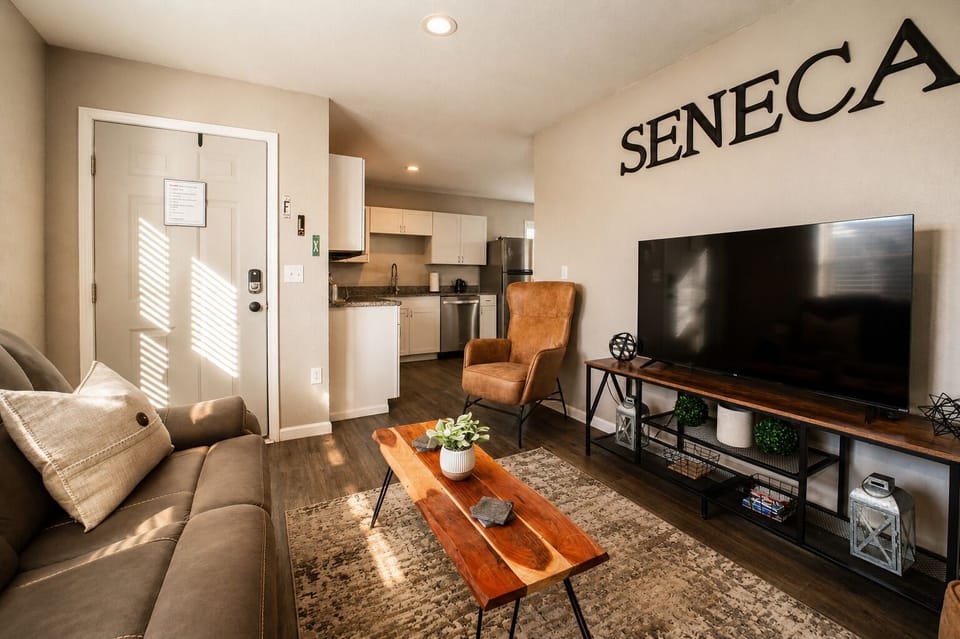 Cozy living room with large TV and open kitchen in a stylish modern layout