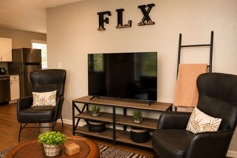 Cozy living room with big-screen TV, leather chairs, and warm modern style