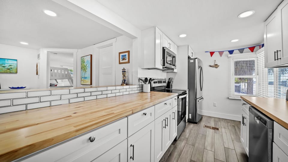 Bright modern kitchen with butcher-block counters and stainless appliances