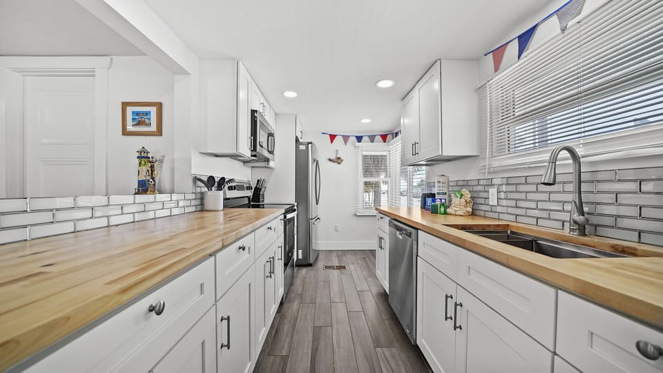 Bright modern kitchen with butcher block counters & stainless appliances