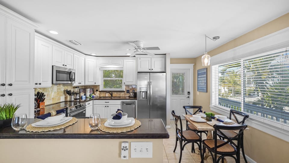Bright coastal kitchen with breakfast bar and sunny dining nook