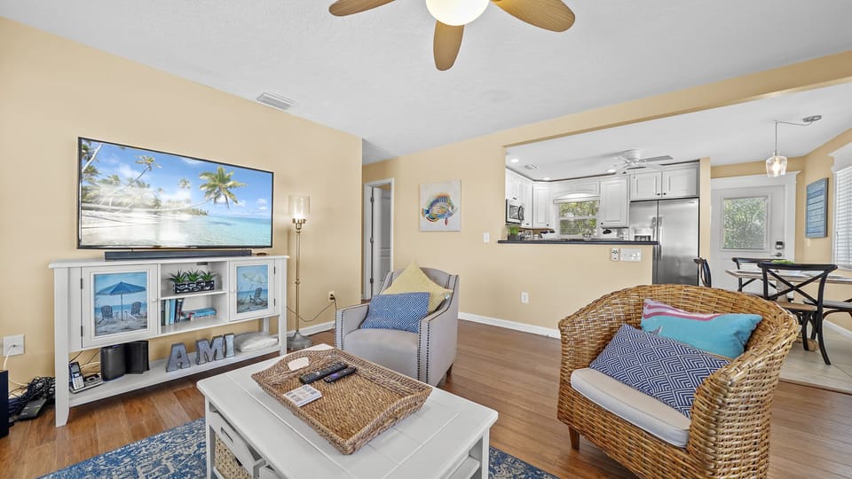 Bright coastal living room with open kitchen and cozy seating