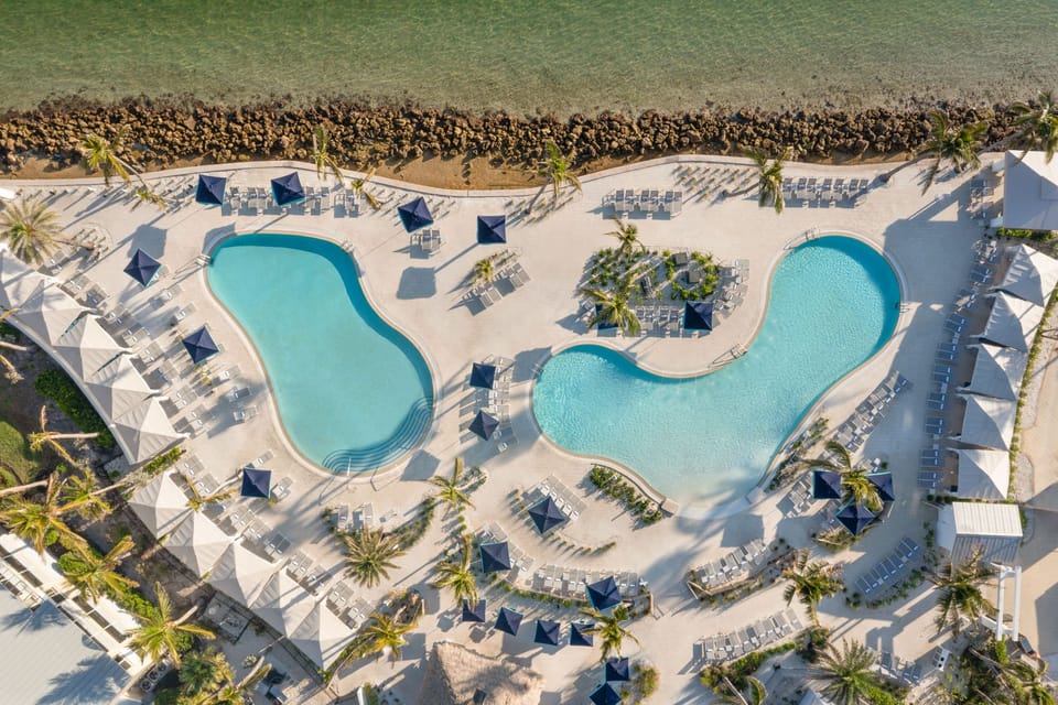 Cabanas and poolside seating line the deck, offering shade between swims.