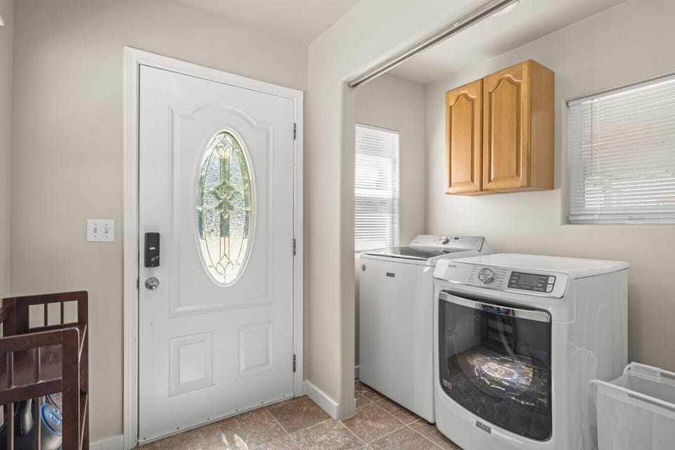 Main Level: Laundry room with a full-size washer, dryer, and ironing essentials for your convenience.