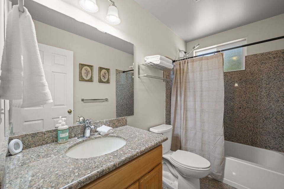 Upper Level Ensuite Bathroom :Private bathroom with a bathtub, shower, spacious vanity, fresh towels, and complimentary toiletries.