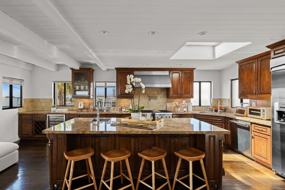 A spacious kitchen island with stone countertops and bar seating, perfect for gathering together.