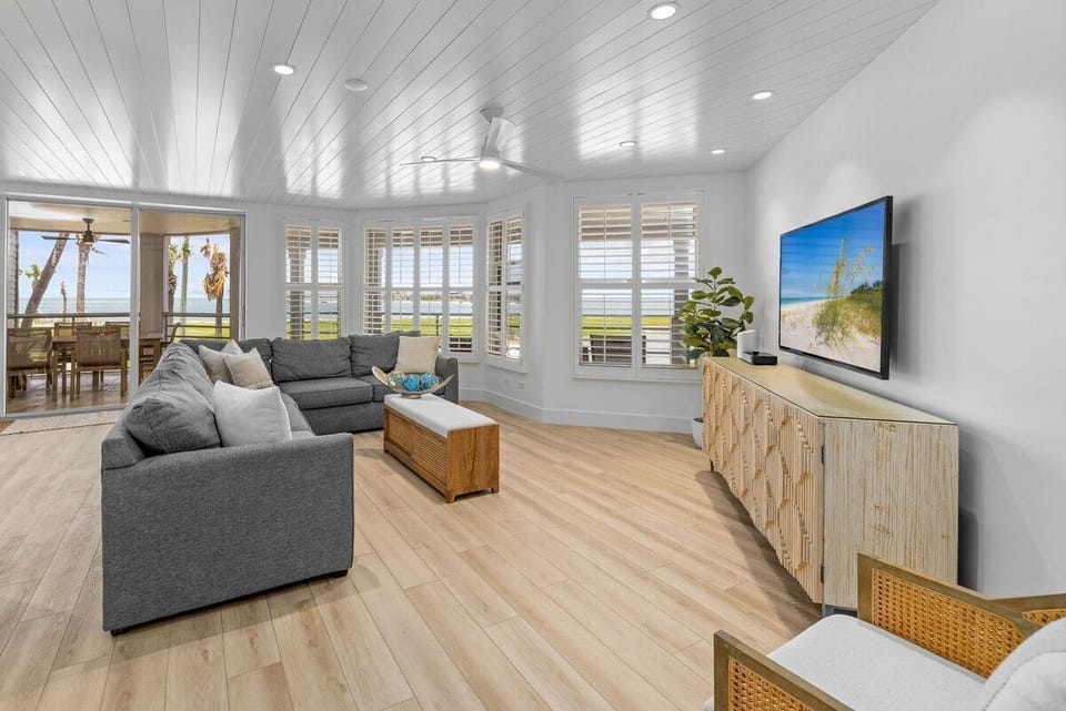 The living room with comfortable sectional seating, a TV, and direct access to a furnished patio.