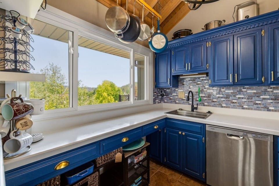 Enjoy preparing meals while taking in beautiful wooded views through oversized windows. This bright kitchen combines modern amenities with plenty of natural light.