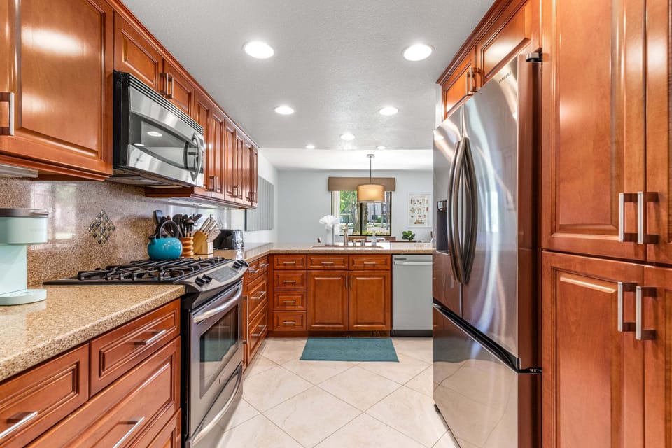 Stainless steel appliances, cooking essentials, and easy flow into the dining space.
