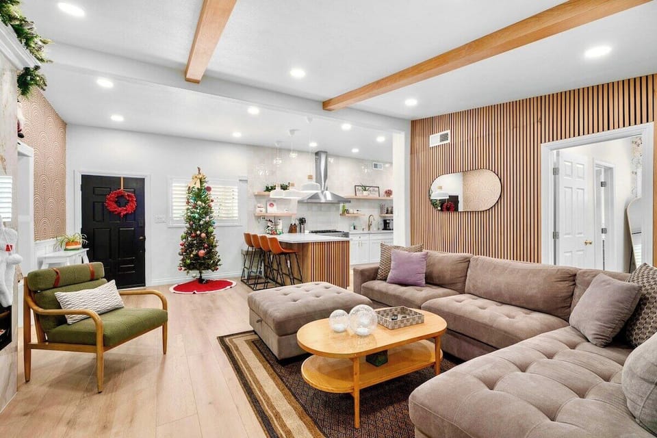 This welcoming and open-concept living area features a spacious sectional sofa alongside the kitchen space. 