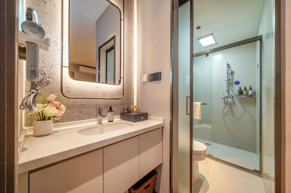 Deluxe Two-Bedroom Family Room | Bathroom | Shower, hair dryer, slippers, towels