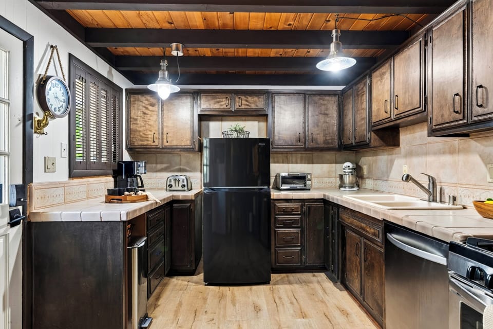 Alternate angle of the kitchen showing counter space and black appliances.