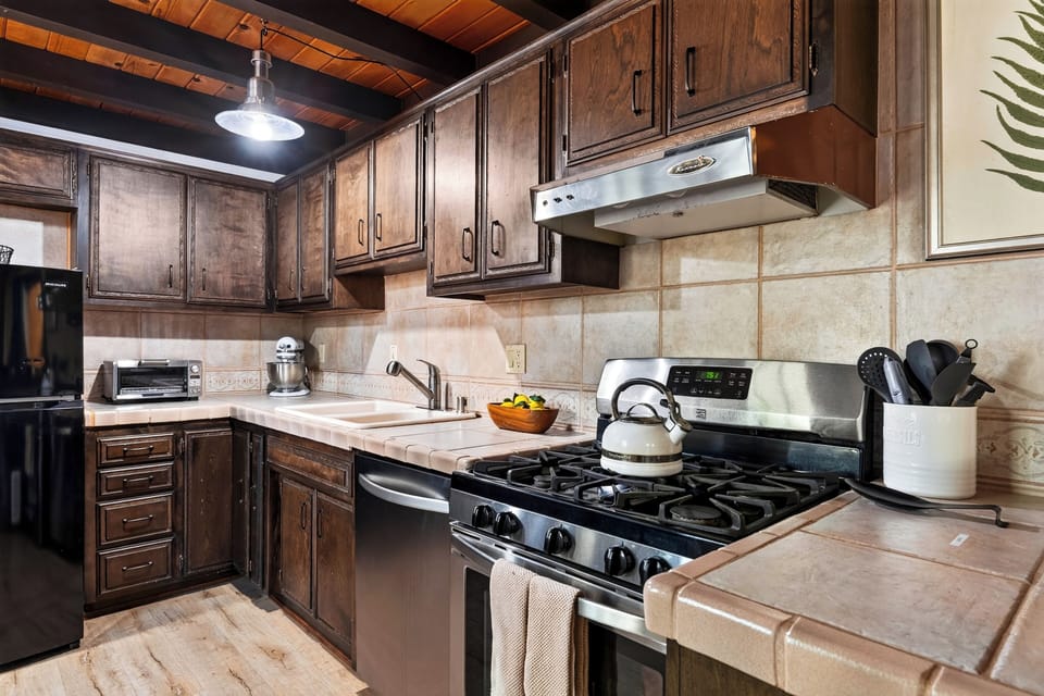Fully equipped kitchen with wooden cabinetry and modern appliances.