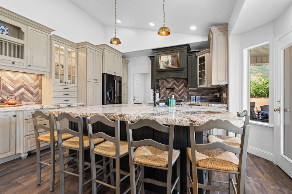 A grand island anchors the kitchen, offering generous prep space and bar seating for guests to gather while meals are prepared.