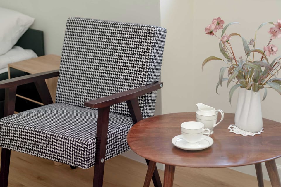 A cozy seating area with a small table, perfect for enjoying coffee or tea. Decorative touches create a warm and inviting atmosphere.