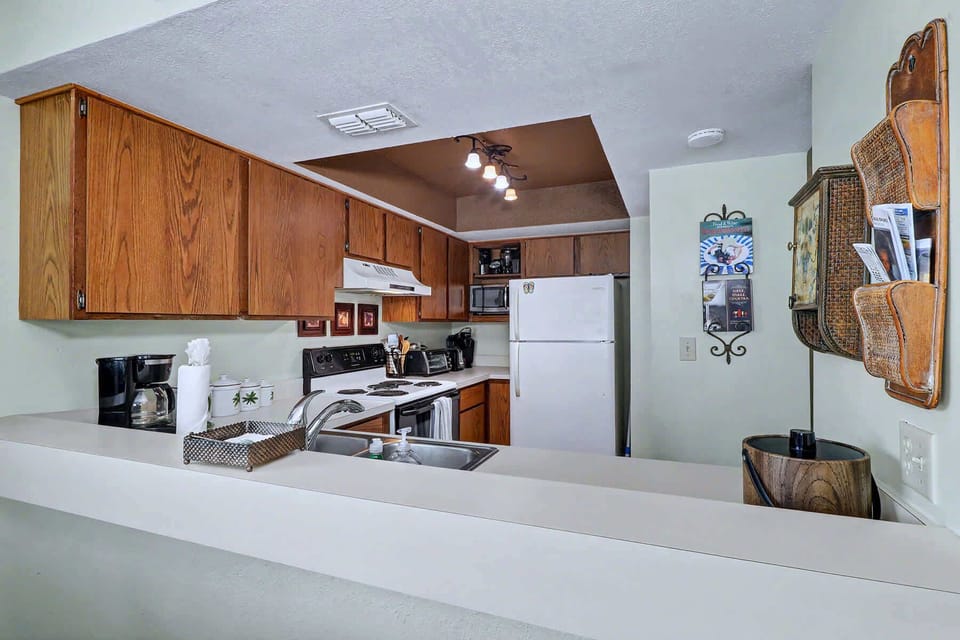 The full kitchen from the pass-through side. Full-size fridge, real oven, microwave, and cabinet space to stock up for the whole week.