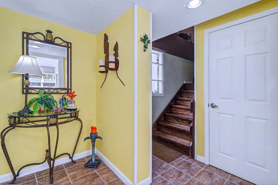 Step inside the front door. A bright entryway sets the tone, closets pull the beach gear out of sight, and the stairs lead up to the living space above.