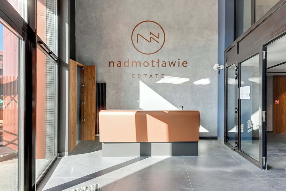 Nowoczesna inwestycja Nadmotławie wyróżnia się elegancką architekturą, zadbanym otoczeniem i stylowo zaprojektowanymi częściami wspólnymi. Kameralne tereny zielone, reprezentacyjne wejście oraz spójna aranżacja budynku tworzą komfortowe otoczenie dla