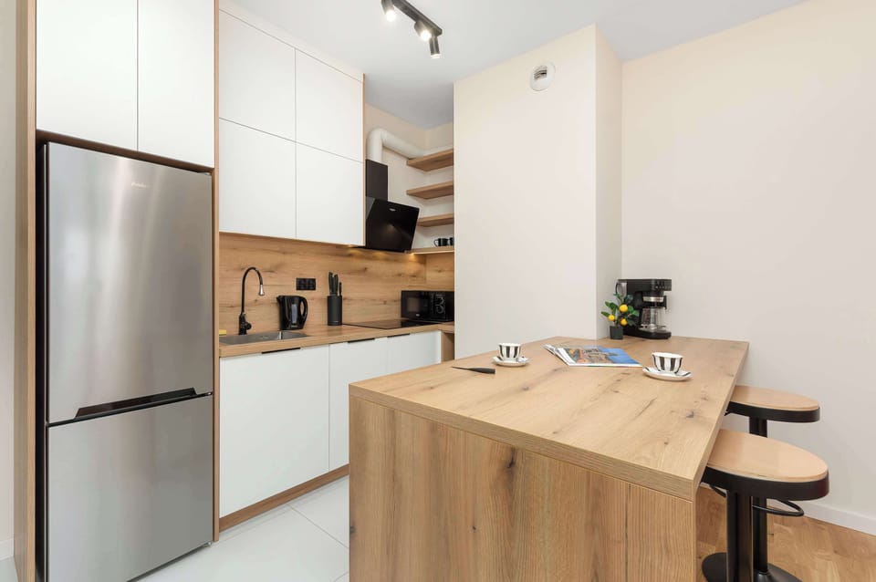 Modern kitchen with a breakfast island, bar stools, and built-in appliances.