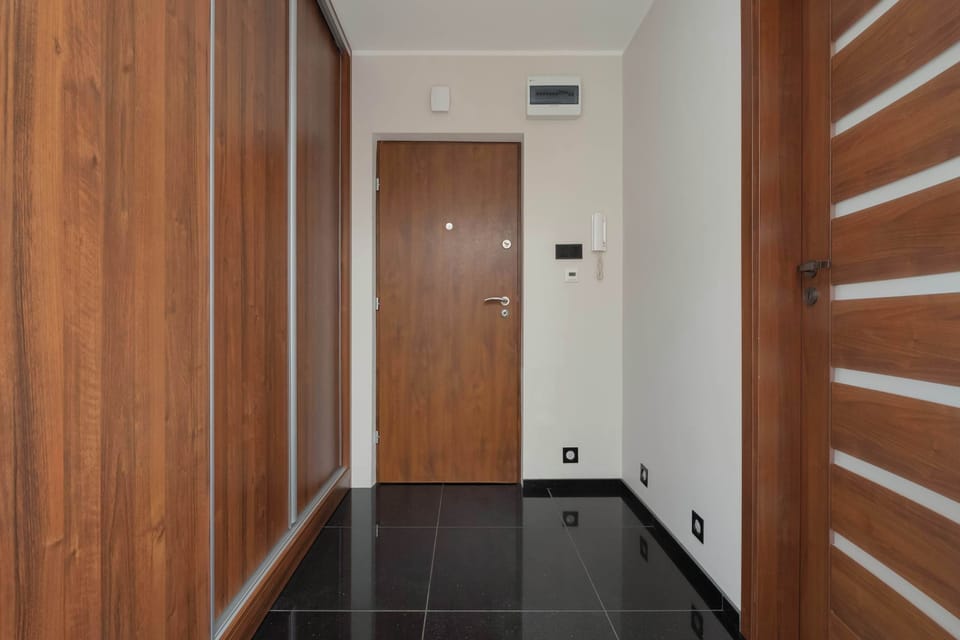 Entrance hallway with wooden doors and practical storage space.