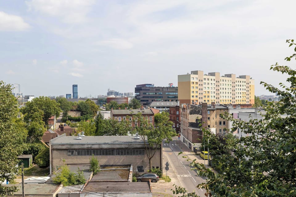 Enjoy an open view of the nearby buildings and greenery from the balcony. It's a pleasant setting to start or end your day.