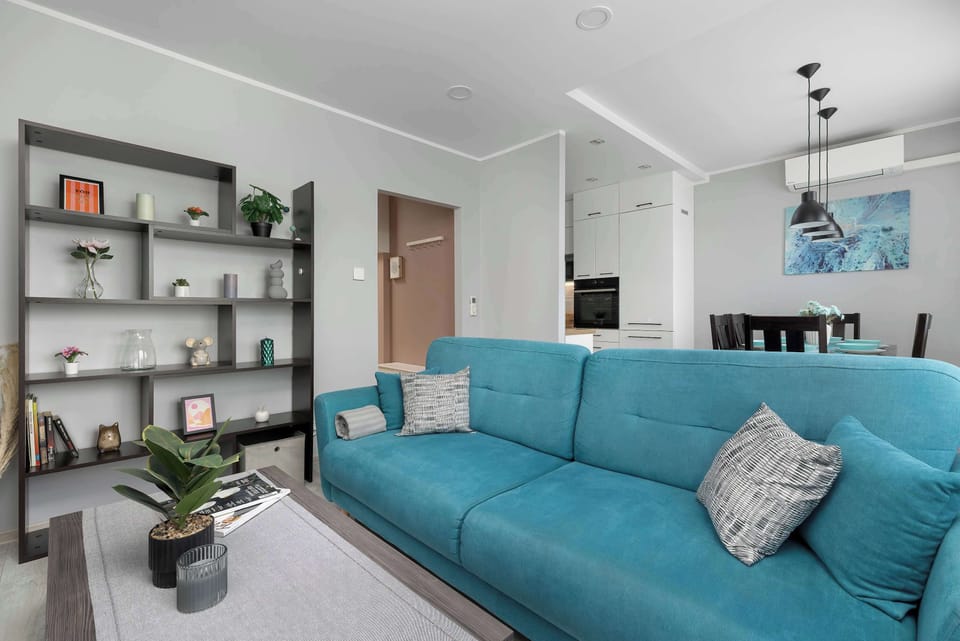 A modern living room with a comfortable sofa bed and stylish shelving. It's the perfect place to unwind after a day of exploring the city.