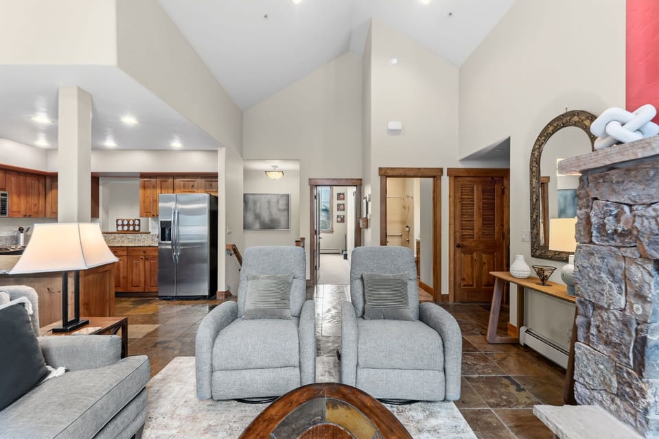 Settle into your open, airy living space with soaring vaulted ceilings and cozy stone fireplace. Plush recliners invite you to relax while warm wood tones and modern comforts create the perfect mountain retreat.