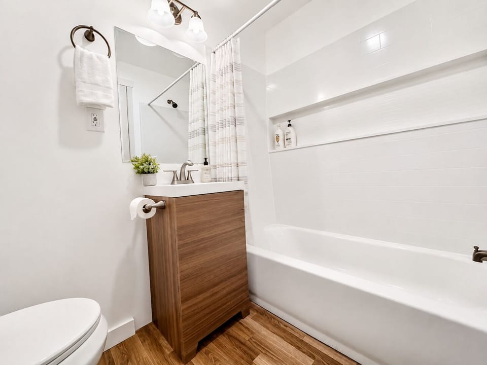 Bright modern bathroom with tub-shower combo and stylish wood vanity