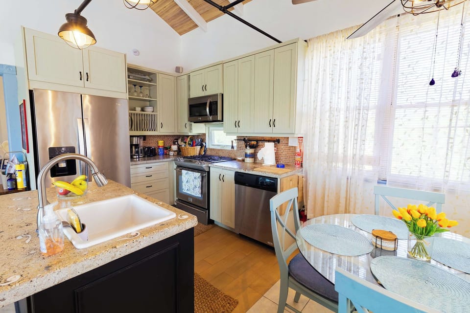 Stainless steel appliances with granite counters and dining nook