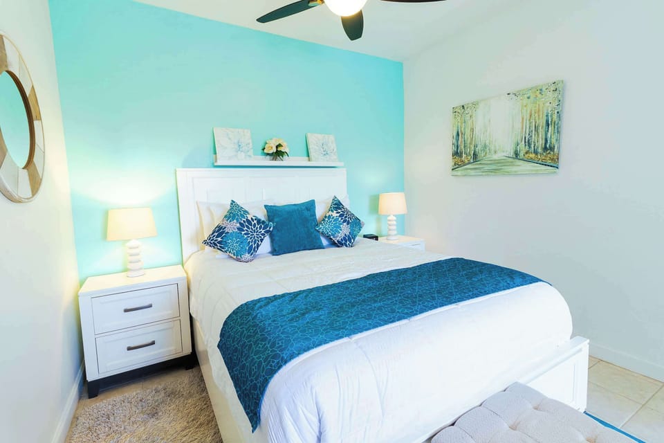 Teal accent wall with queen bed and nightstands