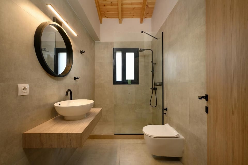 Modern bathroom with a spacious walk-in shower, stylish vessel sink, warm wood vanity, and contemporary natural finishes.