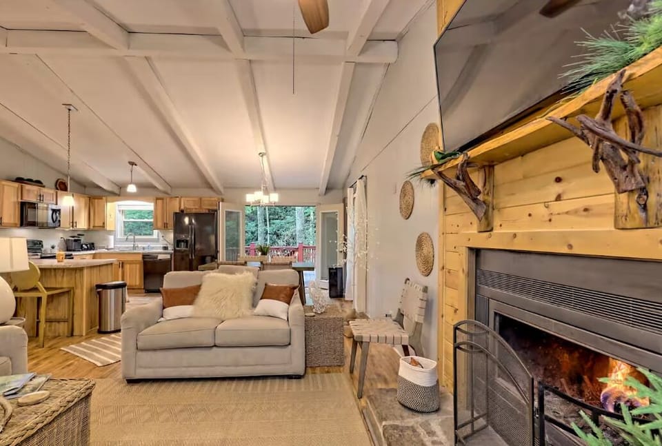 Cozy open living space with fireplace, rustic charm, and bright kitchen