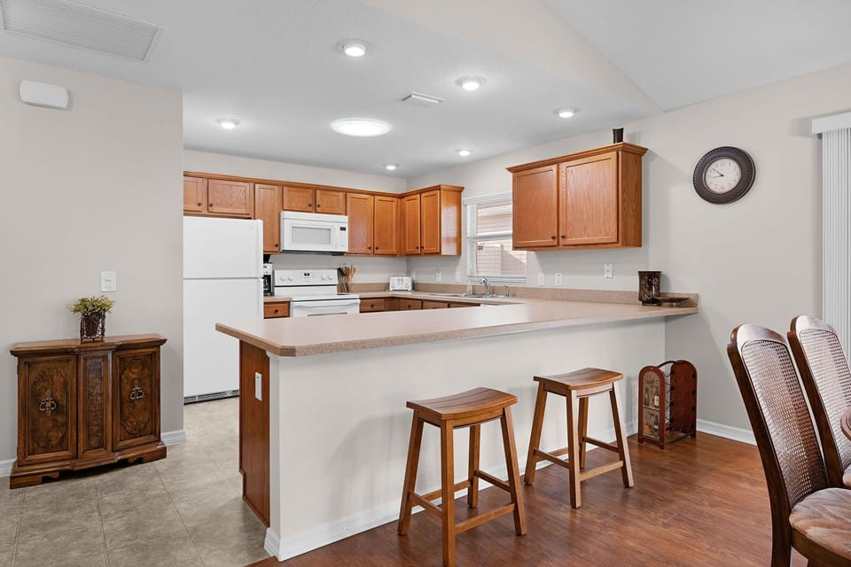 Your spacious kitchen features warm wood cabinetry, a convenient breakfast bar for casual dining, and all the appliances you need to prepare delicious meals during your stay.