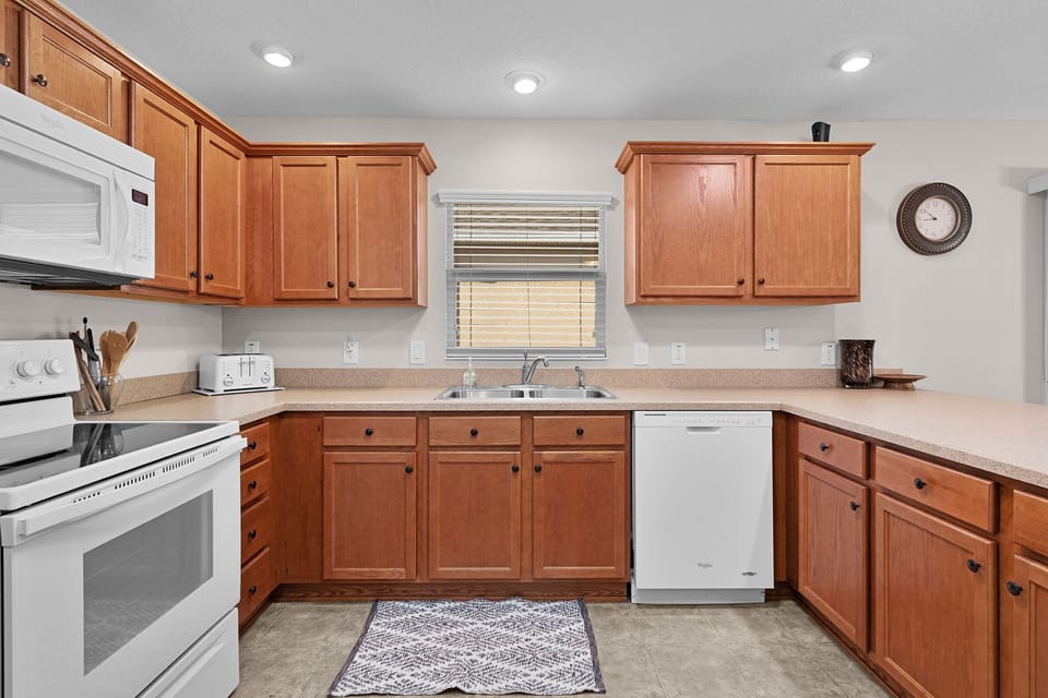 Step into your fully-equipped kitchen with warm wood cabinetry, modern appliances, and plenty of counter space for preparing your favorite meals during your stay.