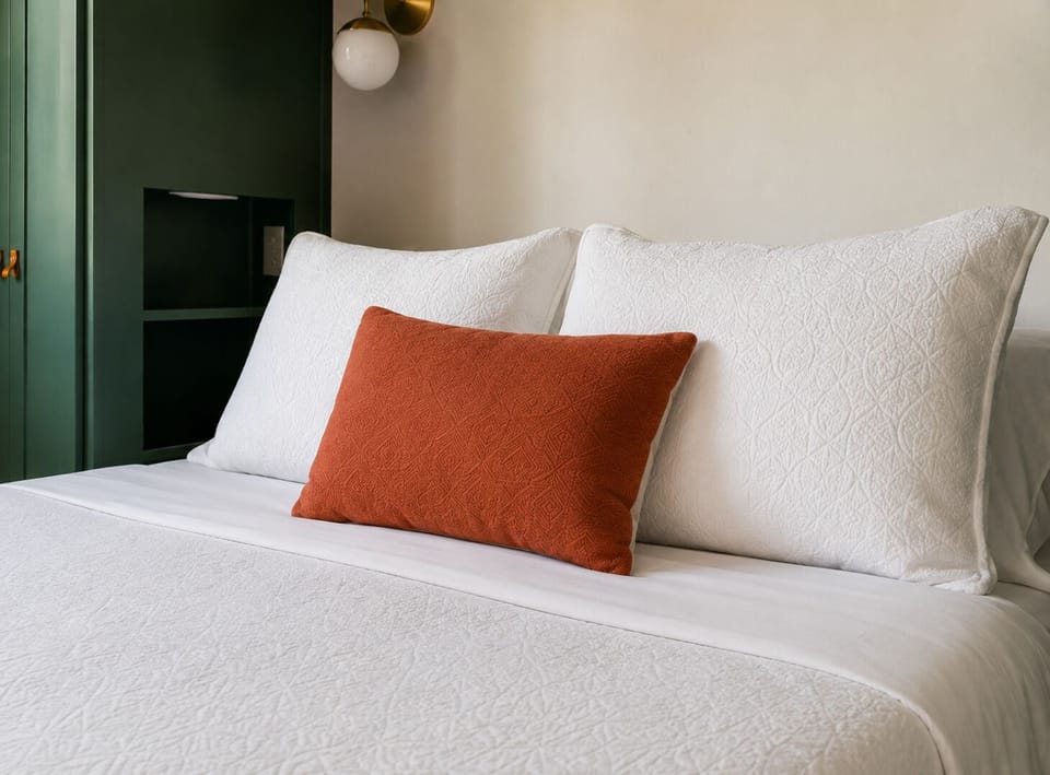 Soft bedding and sconce light make this an easy spot to wind down.