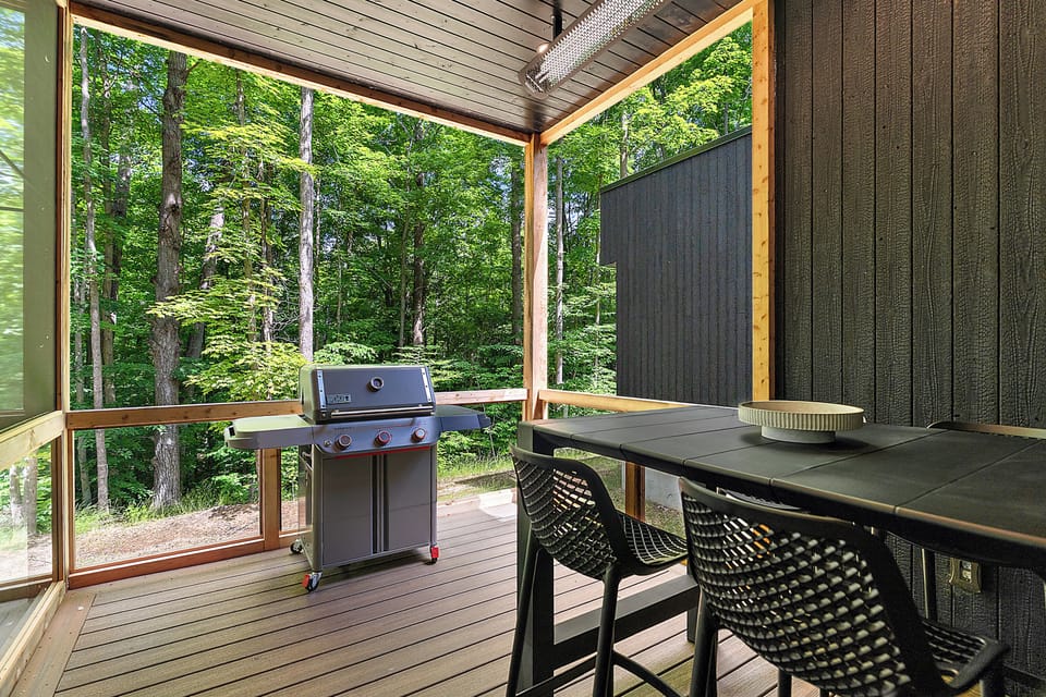 Private covered deck with grill and serene forest-view dining