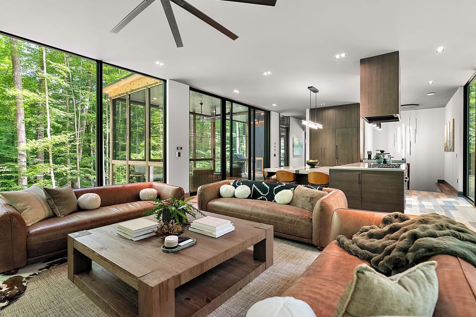 Modern forest retreat with soaring windows and a designer open living space