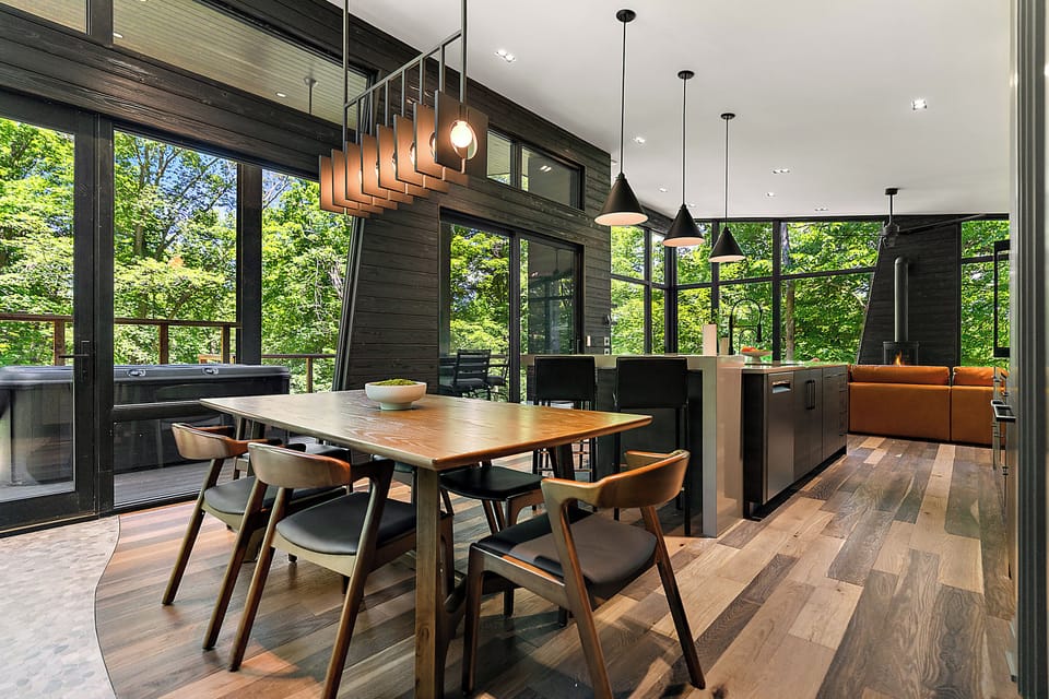 Modern forest-view dining space with deck access and private hot tub