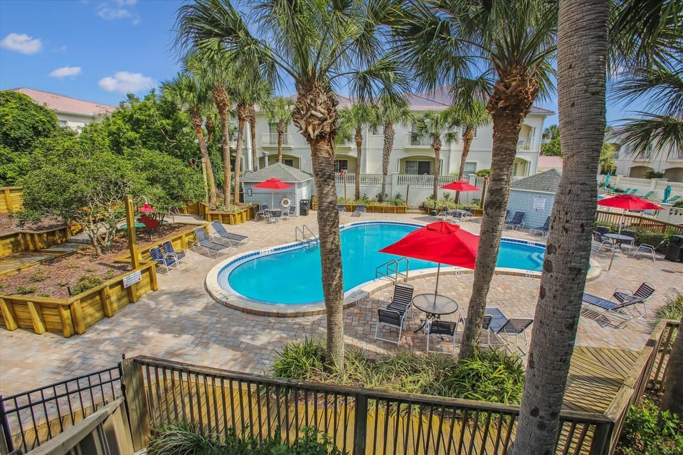 - Large outdoor pool with umbrella seating and tropical palm setting  
- Plenty of lounge chairs for sunbathing and relaxation all day  
- Steps away from your vacation rental for endless poolside enjoyment  