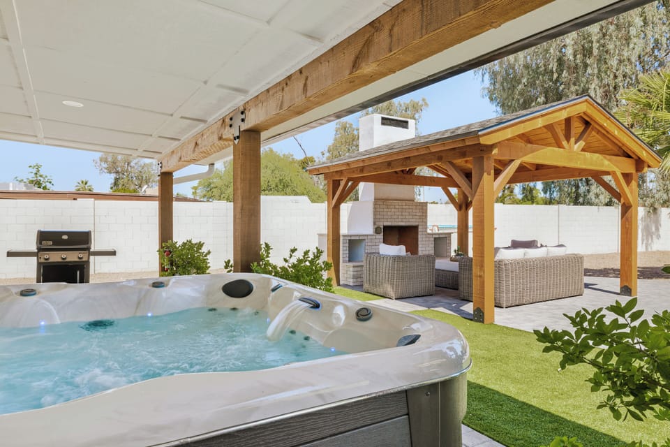 Private backyard oasis with hot tub, gazebo lounge, fireplace, and grill