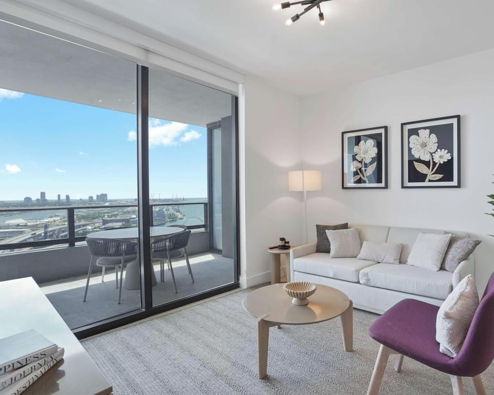 Bright living room with floor-to-ceiling windows and skyline views.