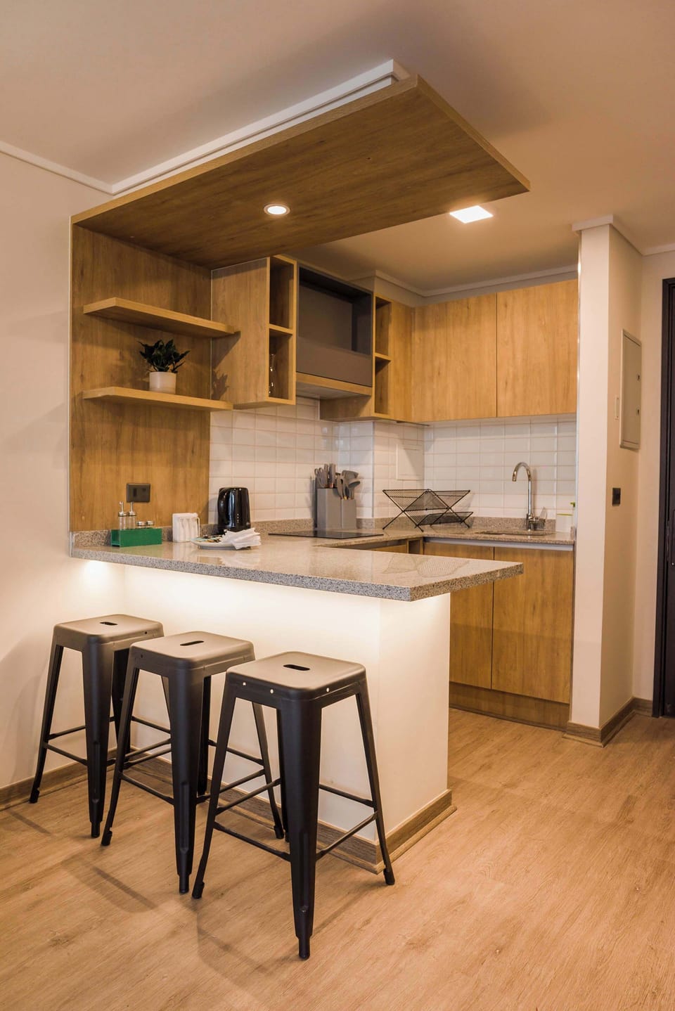 Stylish and modern kitchen with sleek wooden finishes and cozy seating for three.
