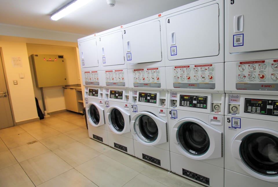 Bright, clean shared laundry room with multiple washers and dryers