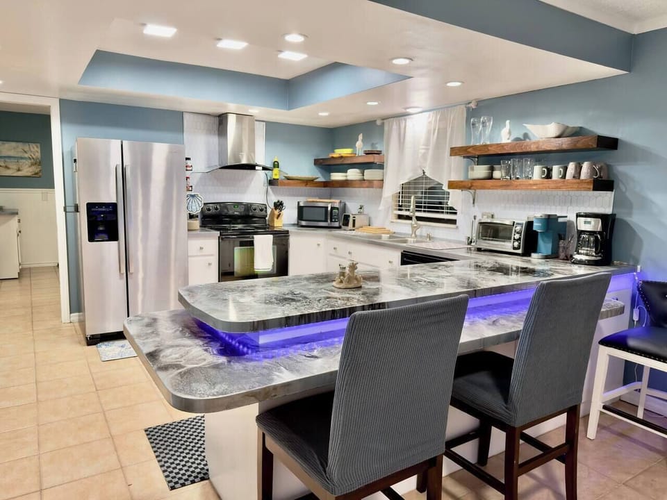 Bar seating, coffee maker, Keurig, toaster oven, toaster, microwave, glasses, mugs, plates, bowls, serving plates 