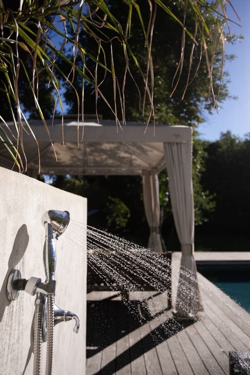 Refreshing outdoor shower conveniently located by the pool.