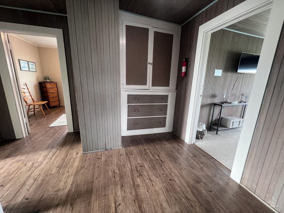 Look up and admire the striking wood-paneled ceiling, adding rustic warmth to your stay. Built-in storage keeps your space tidy, while thoughtful touches like open shelving create a cozy, home-away-from-home feel.