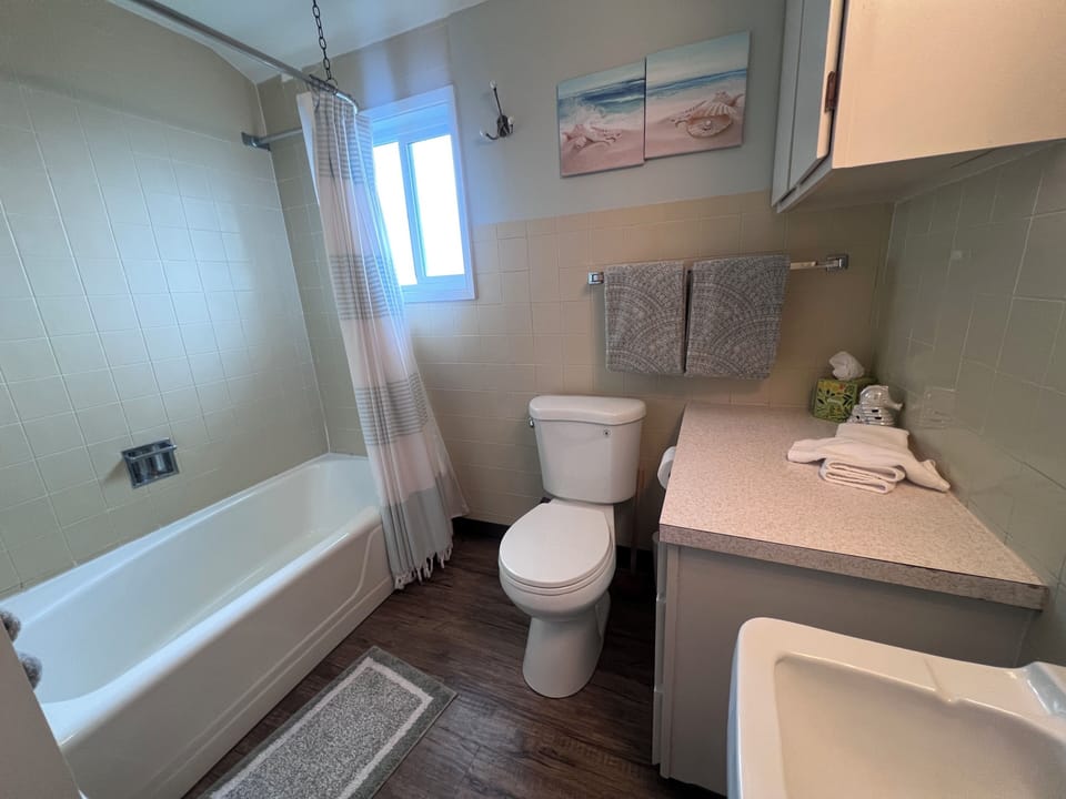 Step into your private bathroom, where modern coastal touches meet everyday comfort. Crisp towels, soothing artwork, and a spacious walk-in shower make this your personal retreat after a day of exploring.