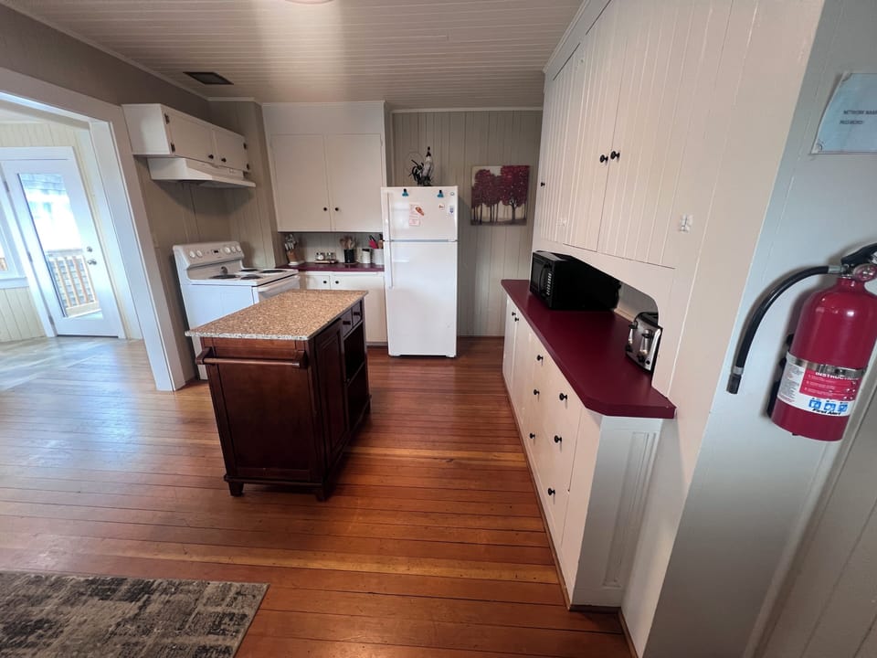 Your cozy kitchen features white cabinetry,  and a compact stove ready for home-cooked meals during your stay.