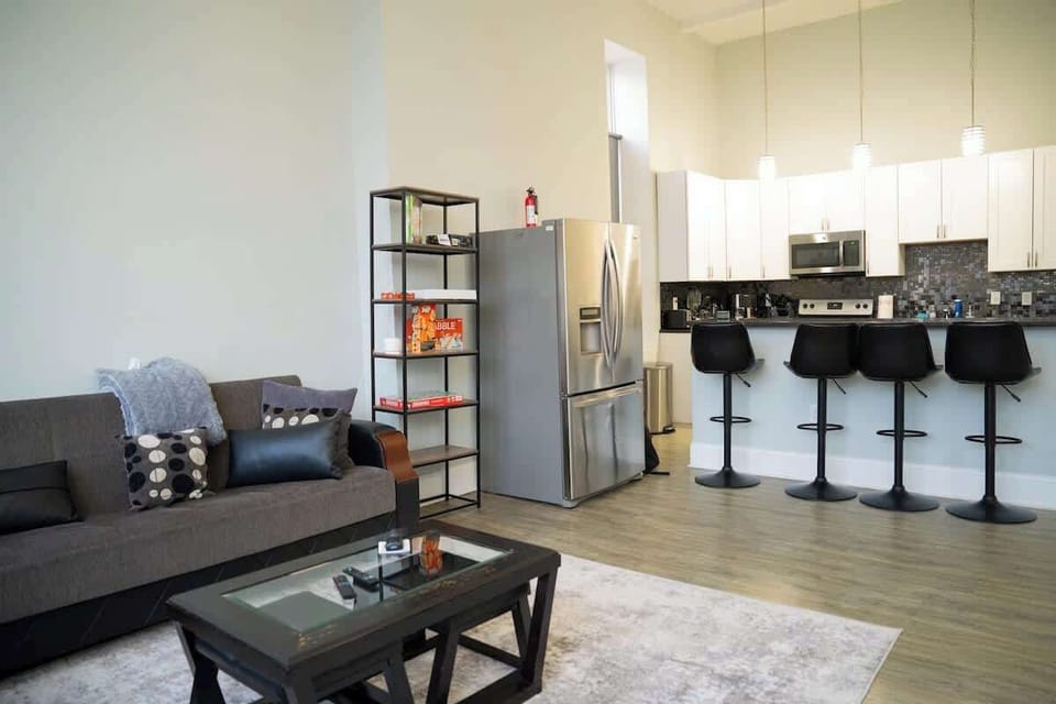 Stylish living room designed for comfort, complete with modern furnishings, a smart TV, and a convenient in-room fridge.